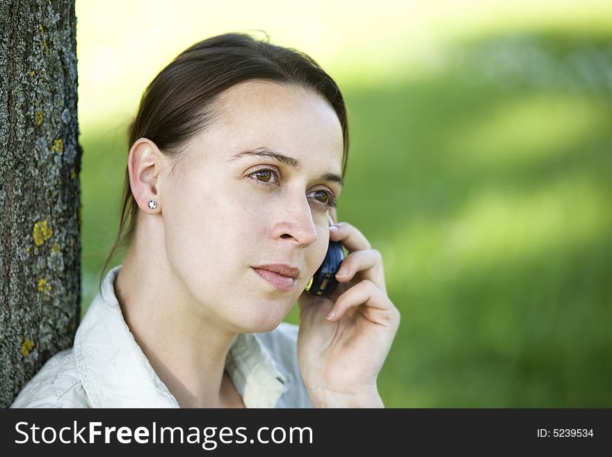 A woman on the phone in an casual outdoor setting. A woman on the phone in an casual outdoor setting