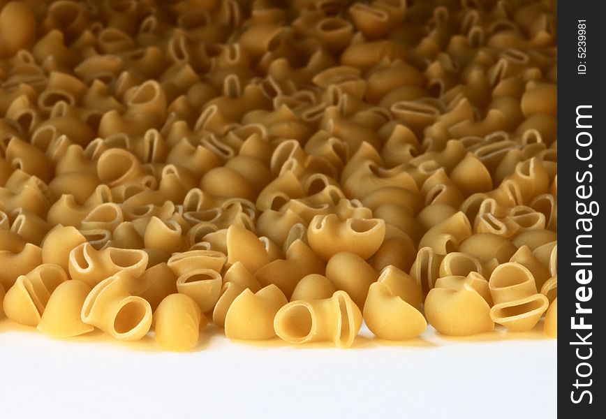 Macaroni made of wheat close-up on white