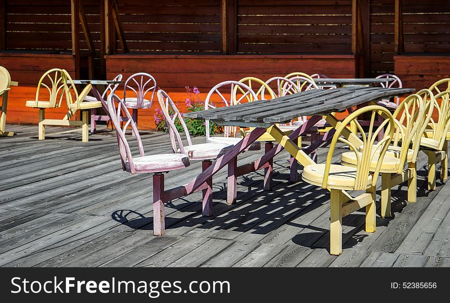 Empty street cafe with old colored metal chairs and wooden floor