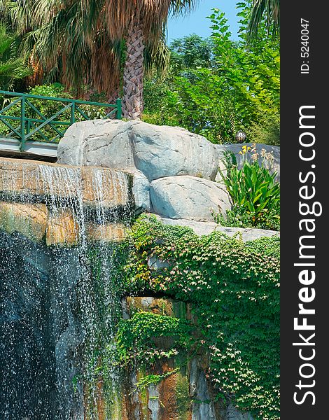 Waterfall and palm trees in park. Waterfall and palm trees in park