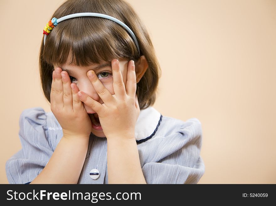 Little girl gazing through her fingers, astonished. Little girl gazing through her fingers, astonished