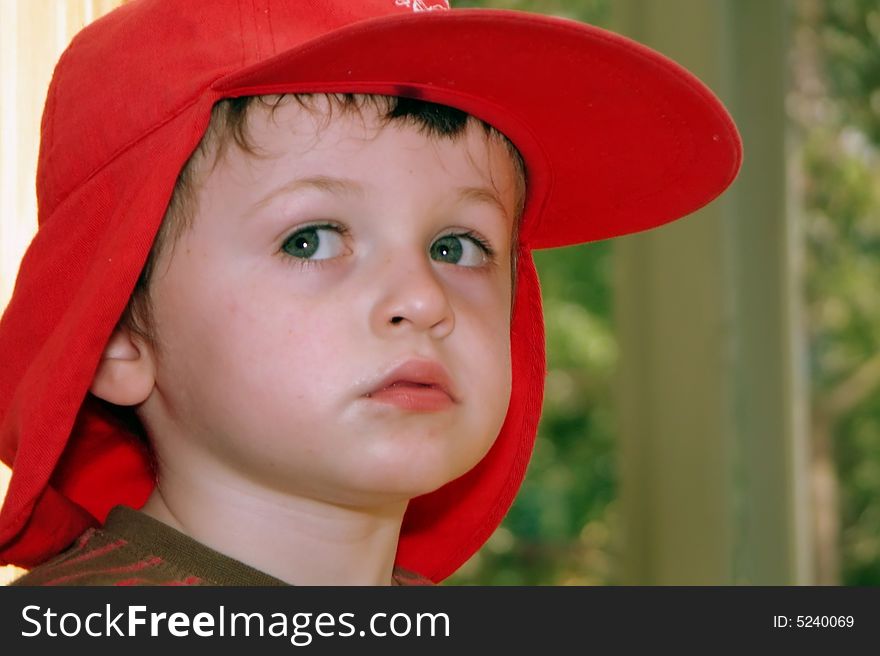 A young child daydreams lost in deep thought gazes into the middle distance perhaps in a home or a classroom environment - with copy space. A young child daydreams lost in deep thought gazes into the middle distance perhaps in a home or a classroom environment - with copy space