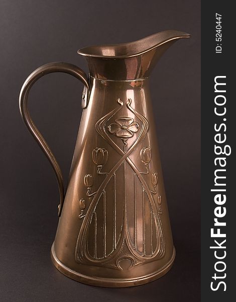 Traditional old brass jug on dark background. Traditional old brass jug on dark background