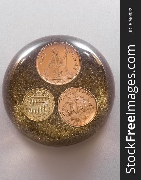 Glass paperweight with three coins