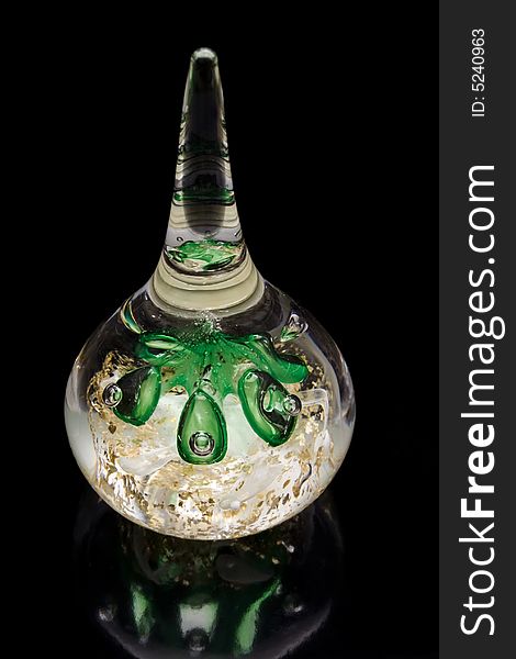 Glass paperweight filled with green bubbles on black