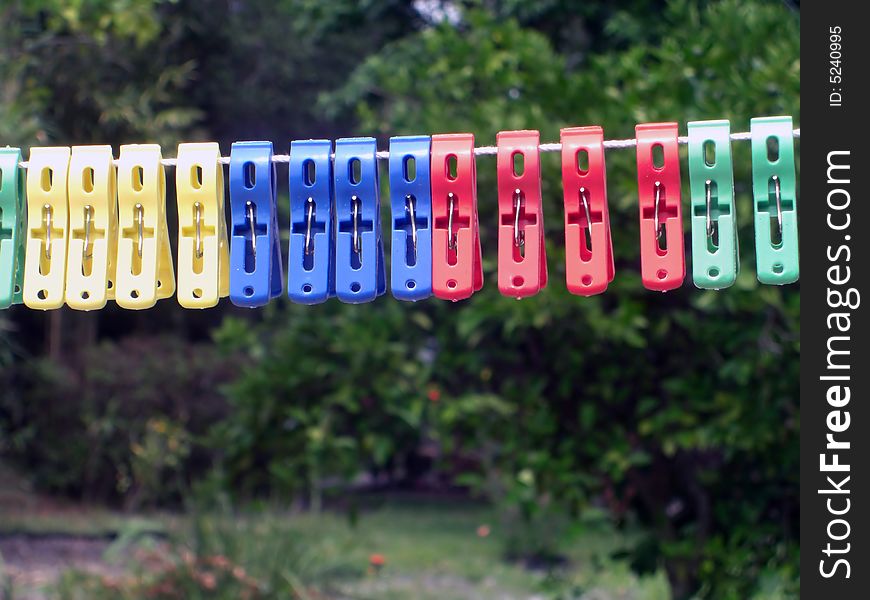 A colorful variety of pegs are on a clothes line. A colorful variety of pegs are on a clothes line