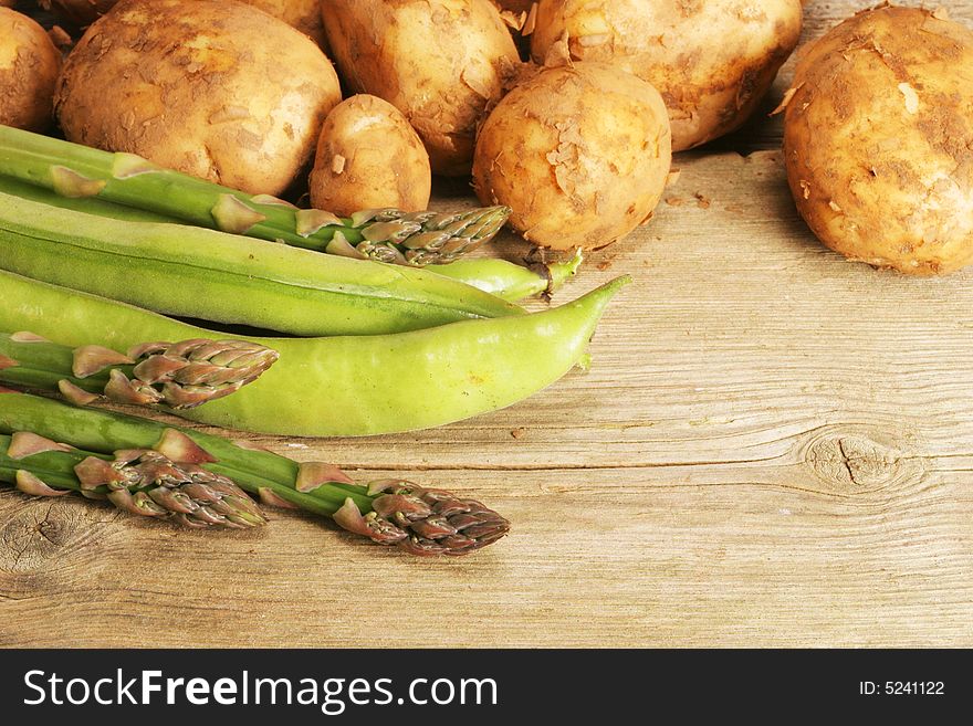 Asparagus,broad beans and new potatoes on old wood. Asparagus,broad beans and new potatoes on old wood