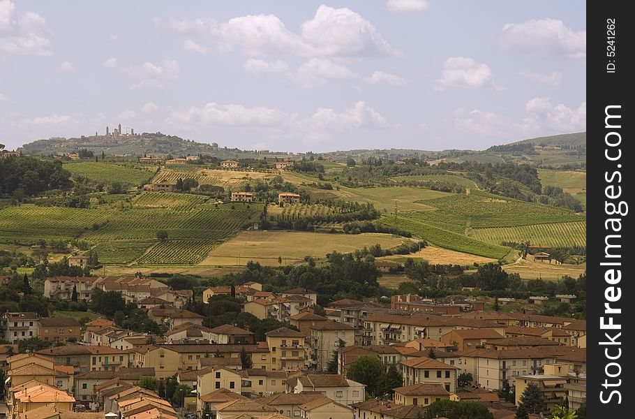 Tuscan village with countryside and vineyards in the background and towers of San Gimignano. Tuscan village with countryside and vineyards in the background and towers of San Gimignano
