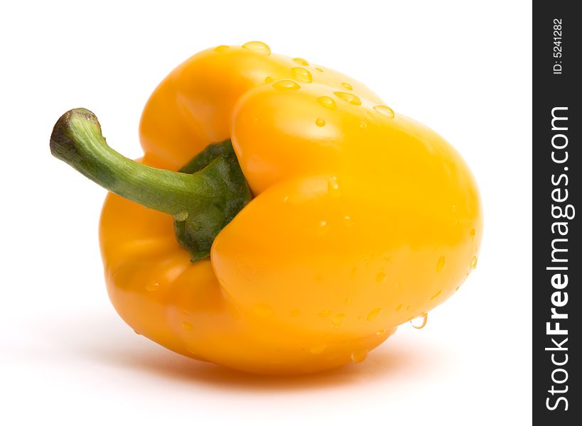 Yellow paprika with water drops over white background