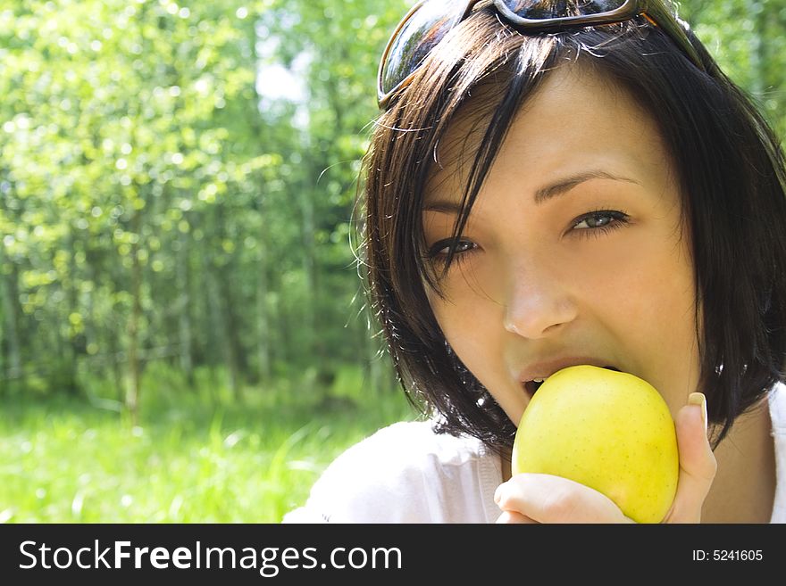 Young happy woman eating apple
