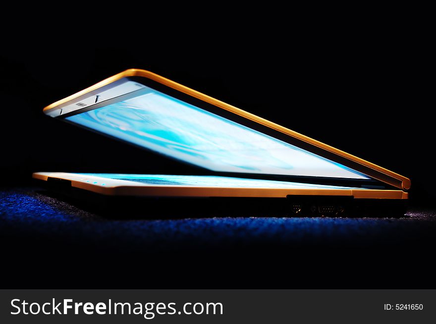 Half-closed gold laptop with blue bright screen