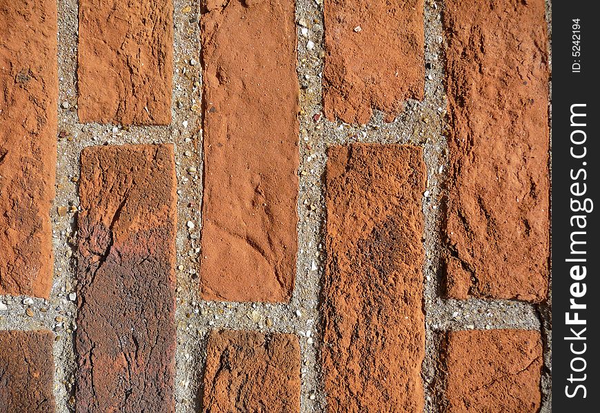 A close up photograph of a brick wall, you can see the texture of the brick.