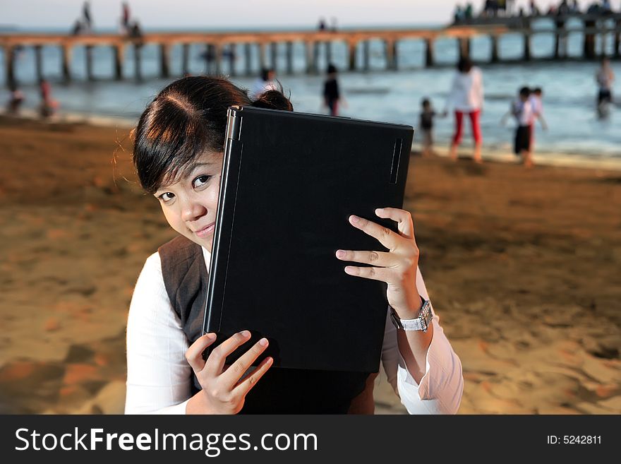 Business woman with laptop at beach