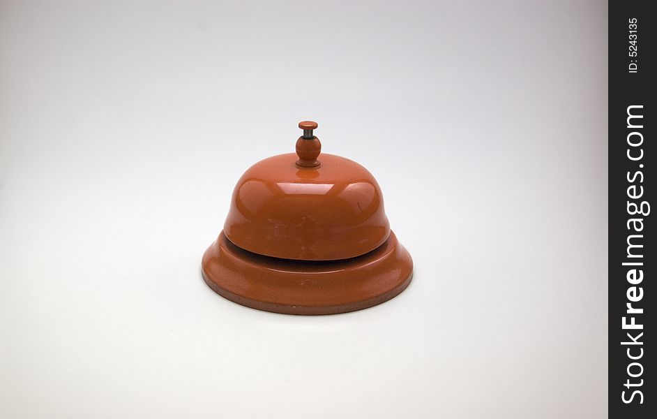 A bright orange bell on a white background