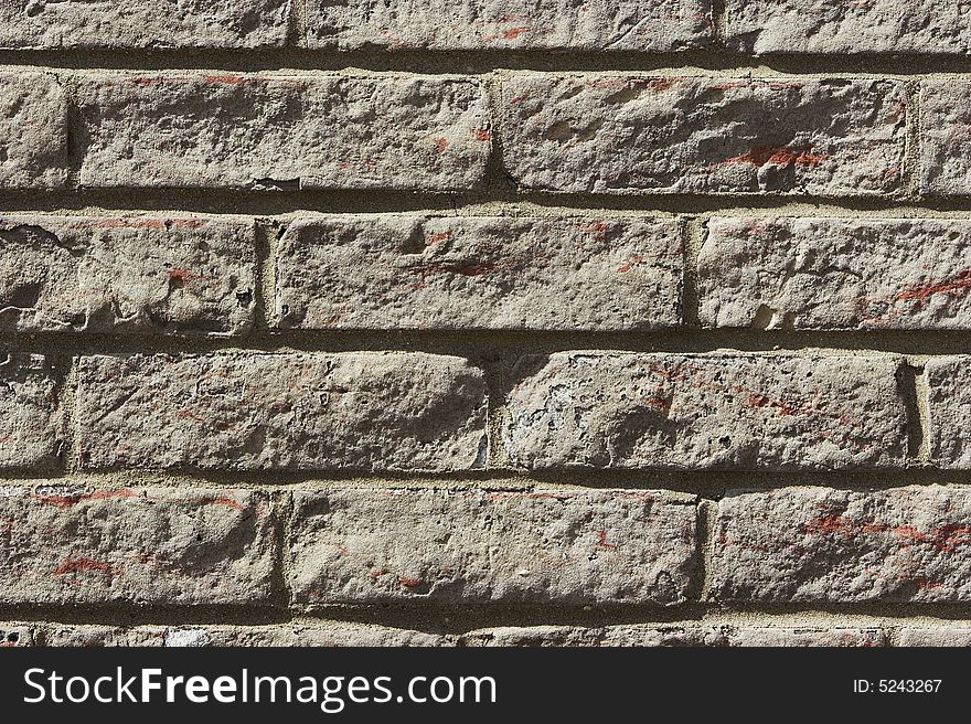 Close up of a brick wall with sunlight coming at a steep angle. Can be used as a background.