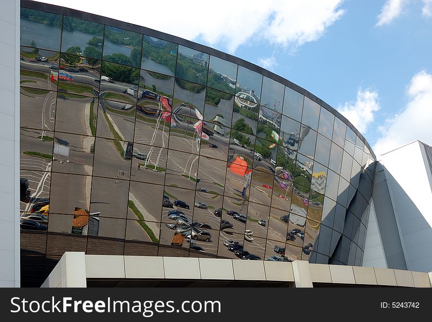 Reflection of a cloudy sky in glass wall of an office building