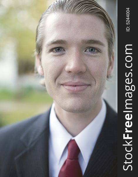 Close up portrait of young businessman smiling wearing suit and tie