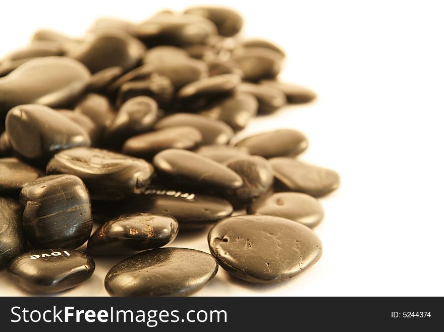 Black pebbles on a white background (shallow DOF)