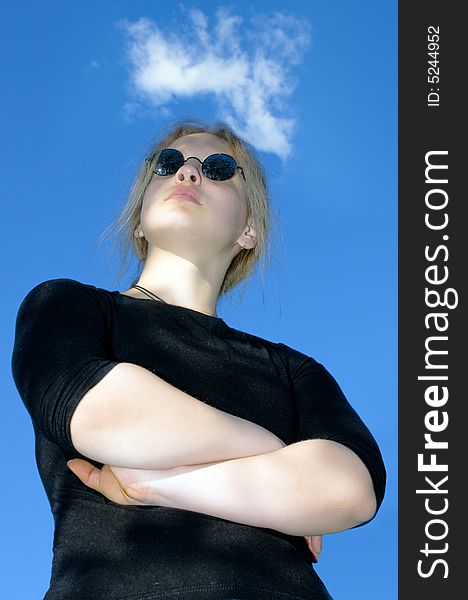 Girl in black glasses against the sky