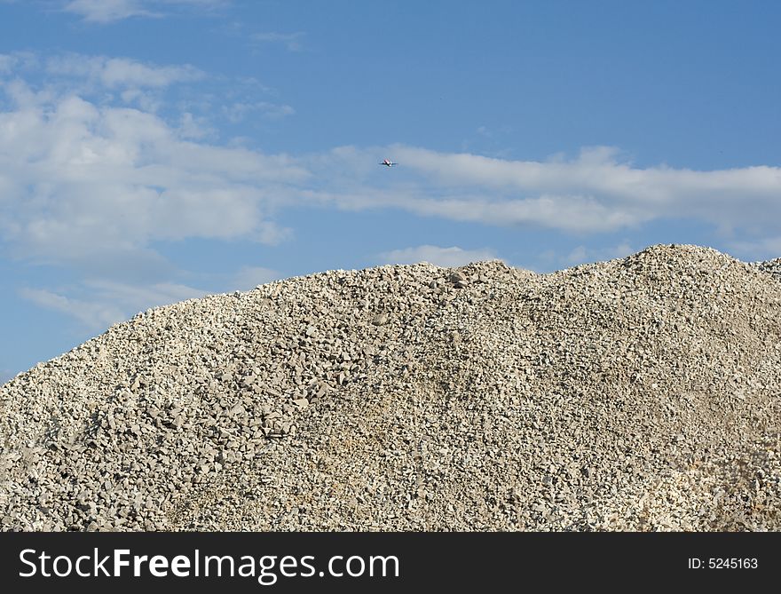 Heap of gravel on the background of blue sky