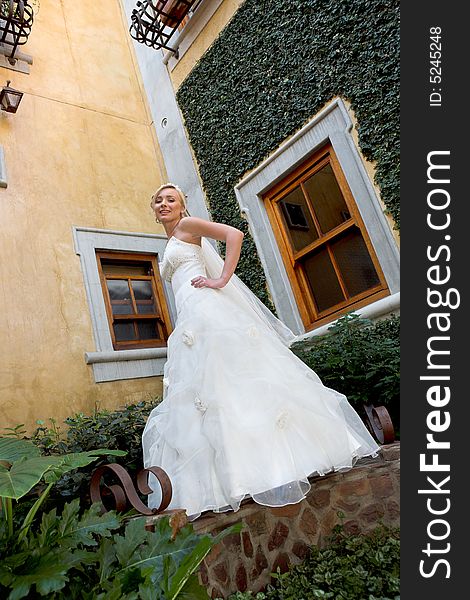 A bride standing in a courtyard in her dress. A bride standing in a courtyard in her dress