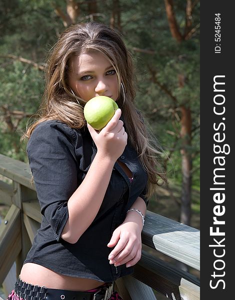 Young girl with apple on forest background