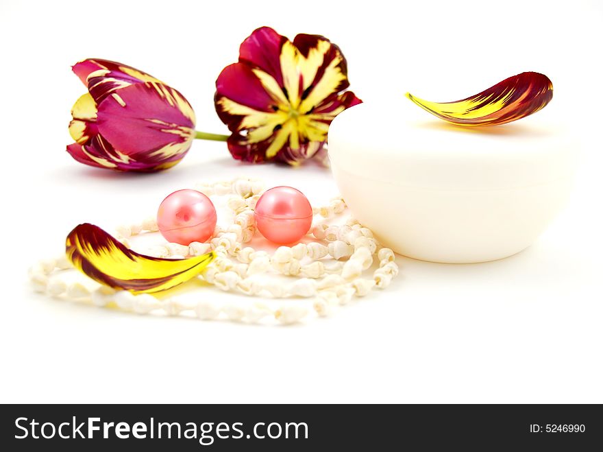 Bath oil arranged with tulip petal and cream