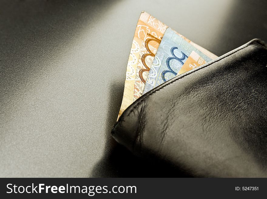 Wallet with banknotes and coins on a grey background. Wallet with banknotes and coins on a grey background