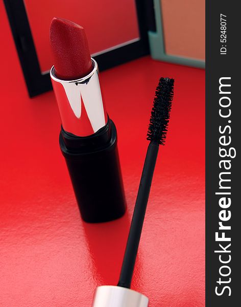Closeup of mascara brush, lipstick and powder. Closeup of mascara brush, lipstick and powder
