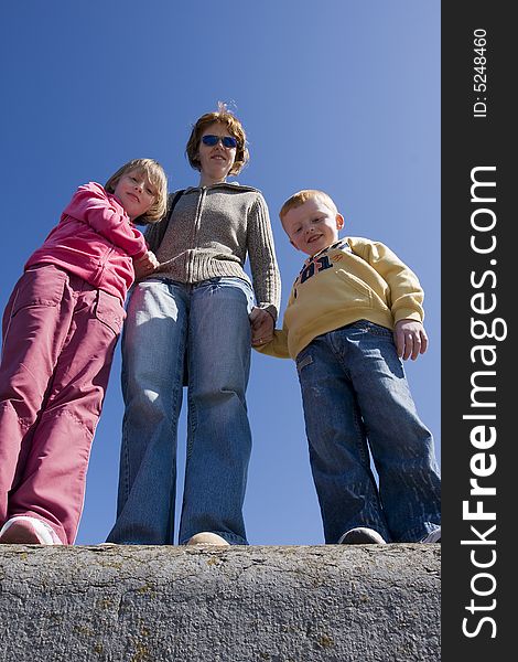 Mother and two children against blue sky. Mother and two children against blue sky