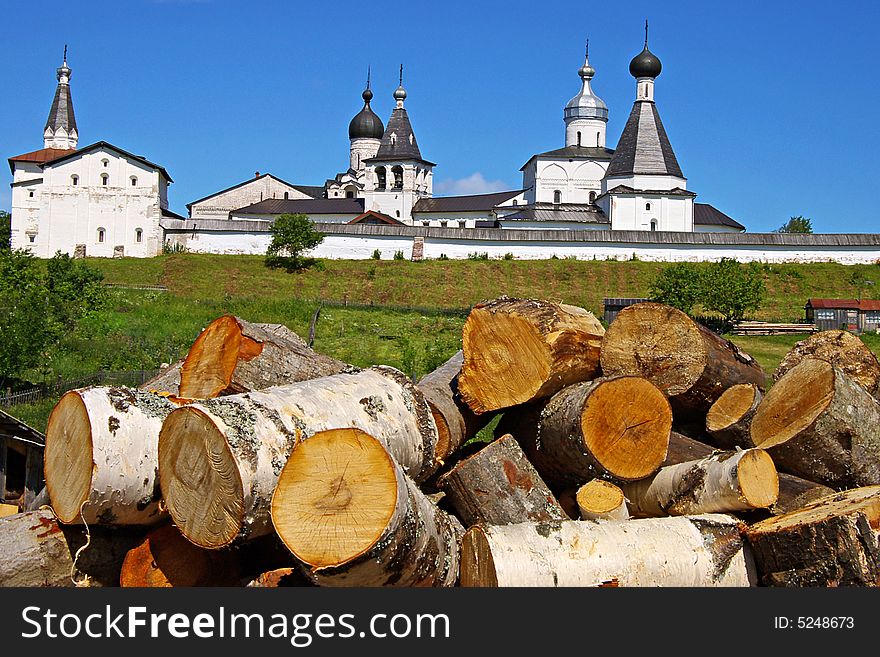 On a photo fire wood on a background of an ancient monastery