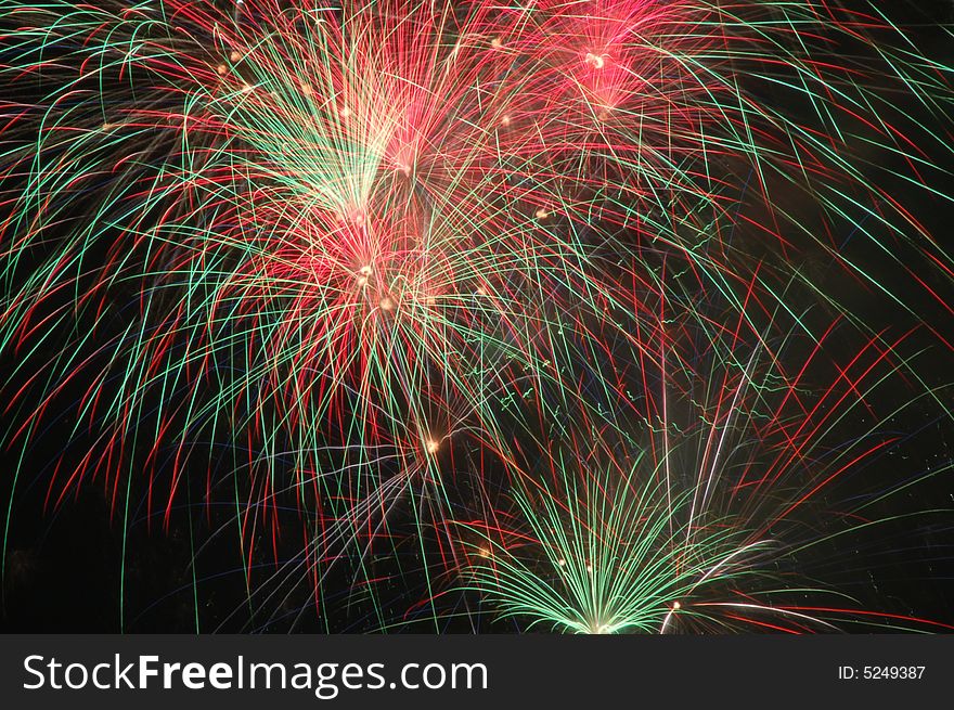 Red green fireworks against black sky