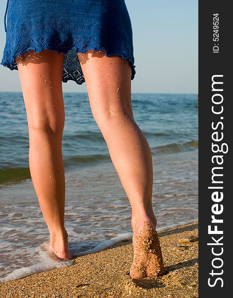 Legs In Blue Skirt Standing In Sea Surf