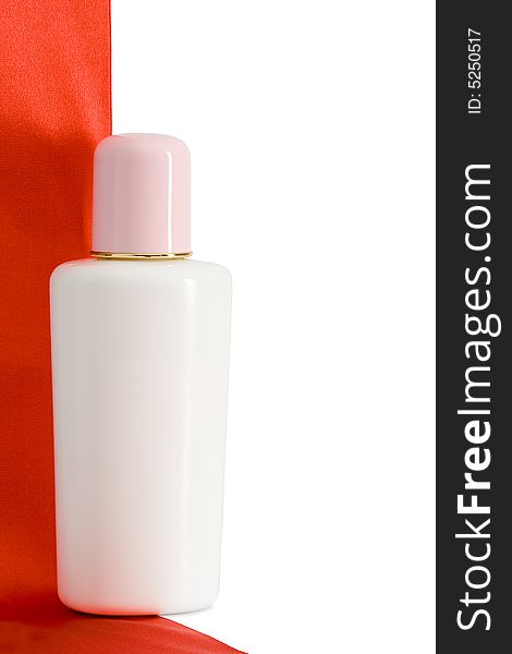 One standing bottle with red satin tape and white background