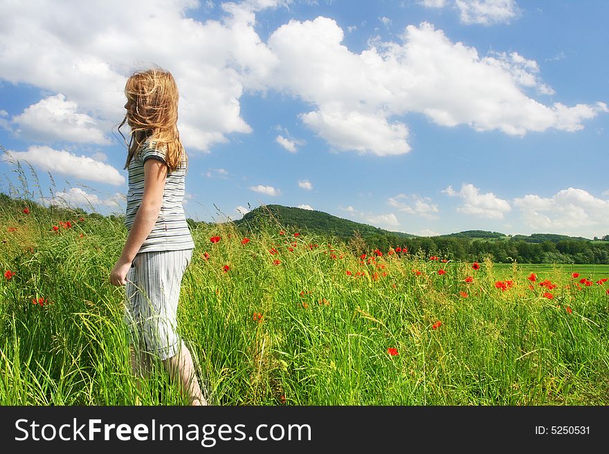 Happy child run on the field with red poppies