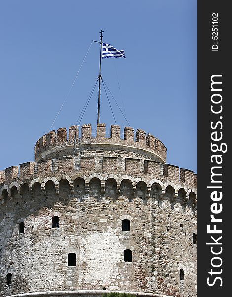 City tower in thessaloniki with greece flag on the top