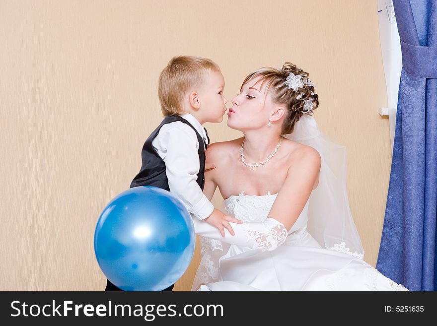 A bride and her li ttle brother of 3 years old kissing. A bride and her li ttle brother of 3 years old kissing