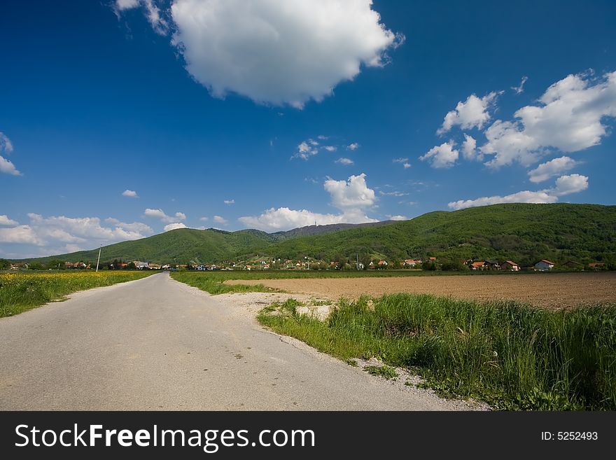 Road on sunny day with mountains in the background