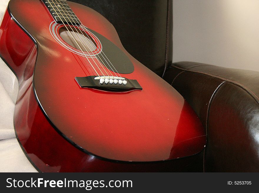Red Guitar on Leather Chair. Red Guitar on Leather Chair