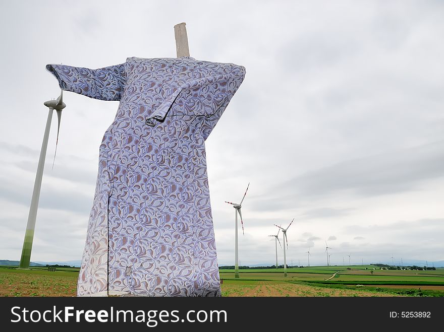 Scarecrow on a corn field with modern windmill. Scarecrow on a corn field with modern windmill