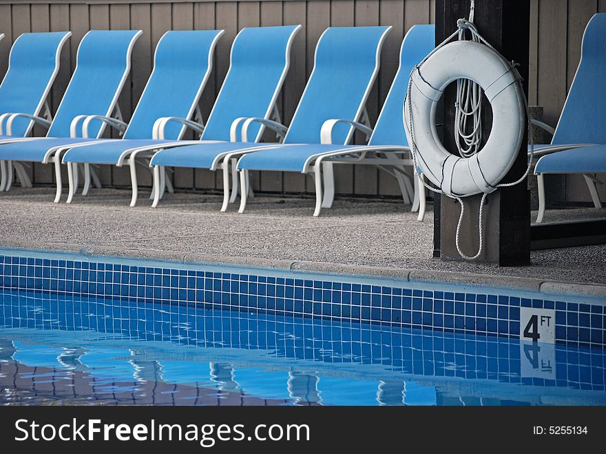 Swimming pool with life preserver and matching chaise lounges. Swimming pool with life preserver and matching chaise lounges.