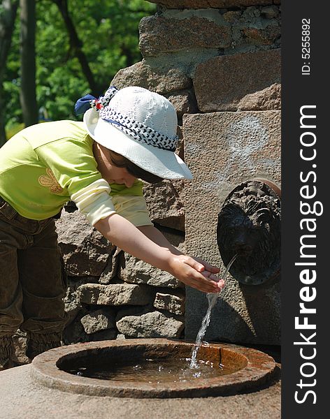 Child and fresh water in fountain