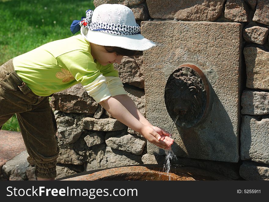 Child and fresh water in fountain