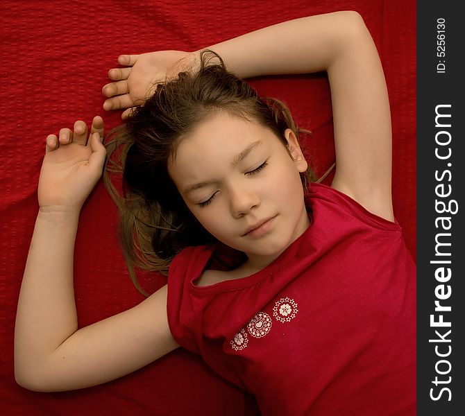 Sleeping young girl in red bed and red shirt