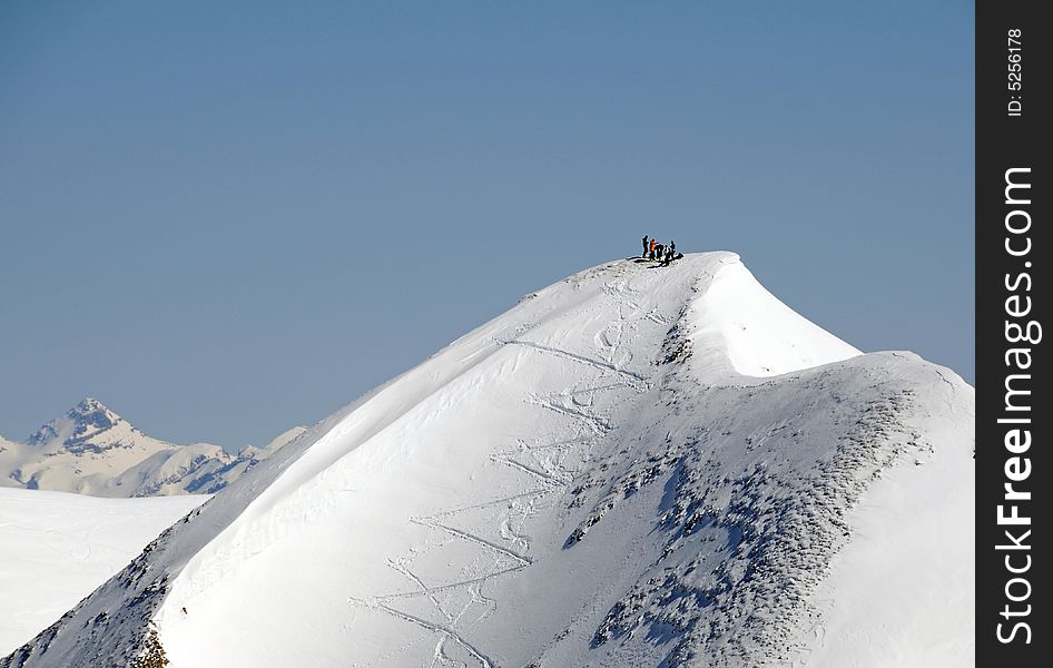 View on snow covered peak with five extrem skiers