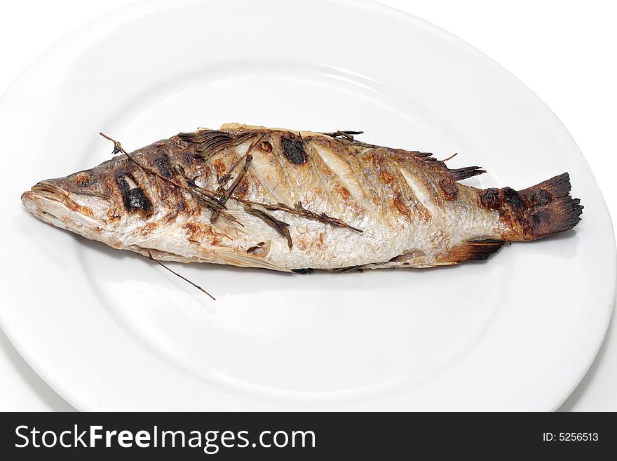 Sea bass with rosemary on a plate.