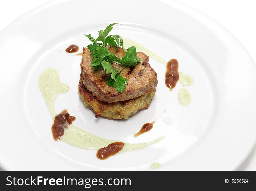 Pork with sauce on a plate isolated over white