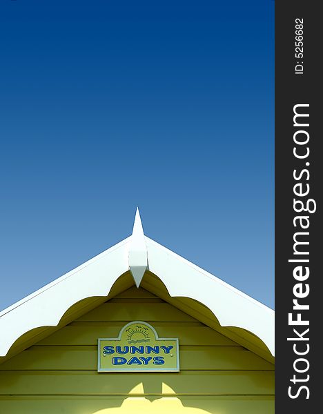 Roof line of a bright yellow beach hut with blue sky. Roof line of a bright yellow beach hut with blue sky