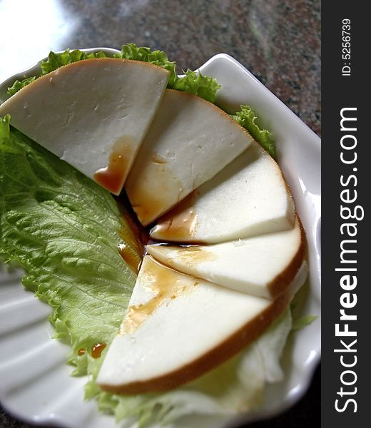 White goats cheese drizzled with honey on a bed of lettuce. White goats cheese drizzled with honey on a bed of lettuce