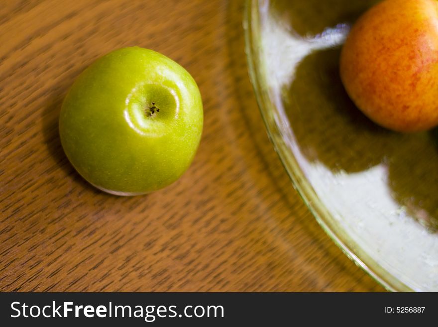 Green apple and plate on table